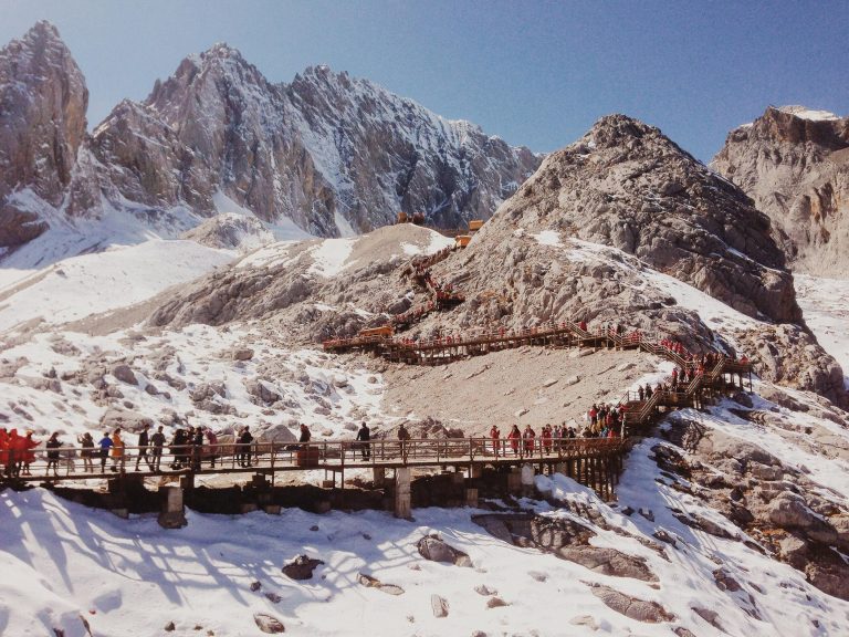 People on a hiking trail in a snowy mountain.
